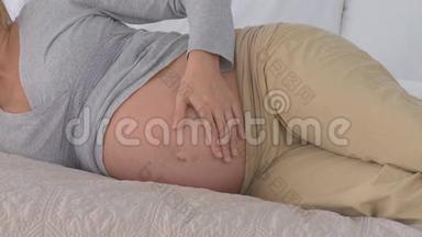 撒谎的孕妇抚摸着她的腹部